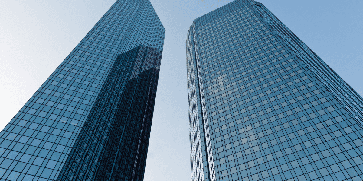 Zwei moderne Glas-Hochhäuser spiegeln sich gegeneinander, Blick nach oben gegen Himmel