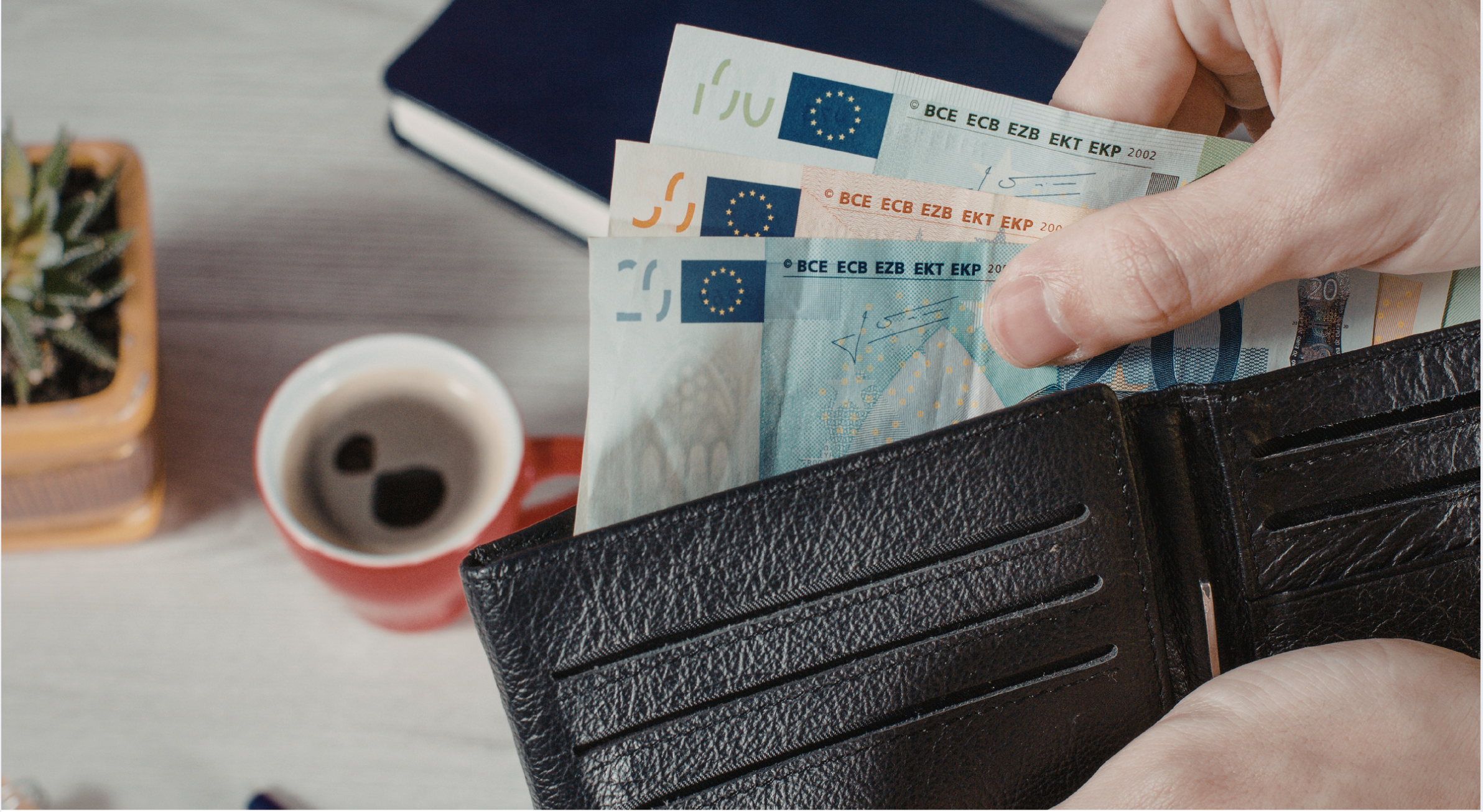 Eine Hand zieht Geldscheine aus einer Geldbörse