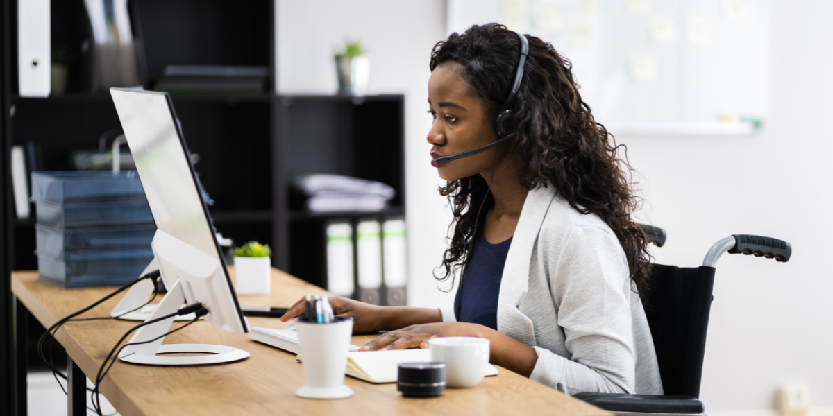 Mitarbeiterin arbeitet am Schreibtisch mit Headset