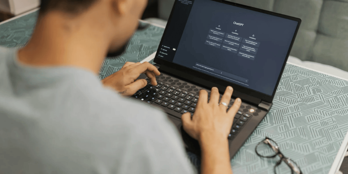 Person tippt an einem Laptop auf der ChatGPT-Webseite