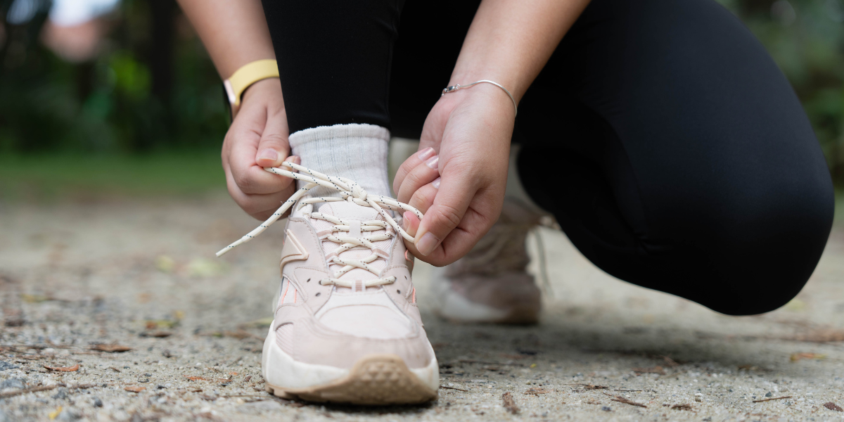 Person bindet Sportschuhe vor dem Laufen