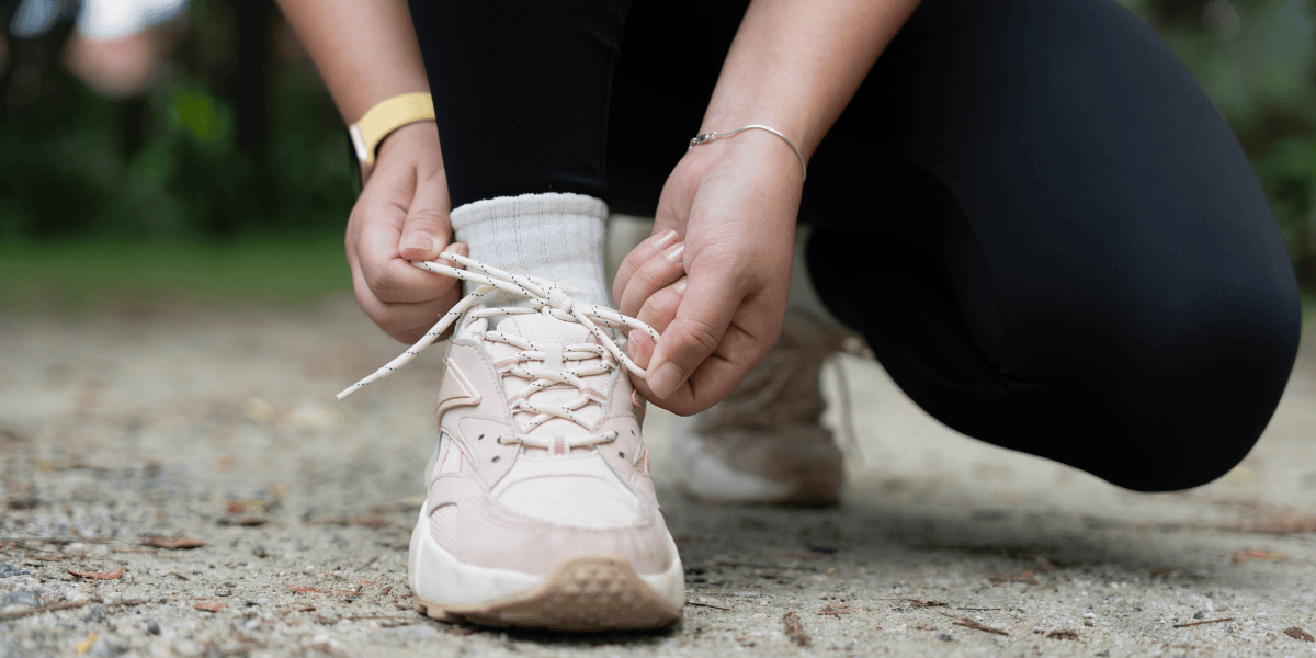 Person bindet Sportschuhe vor dem Laufen