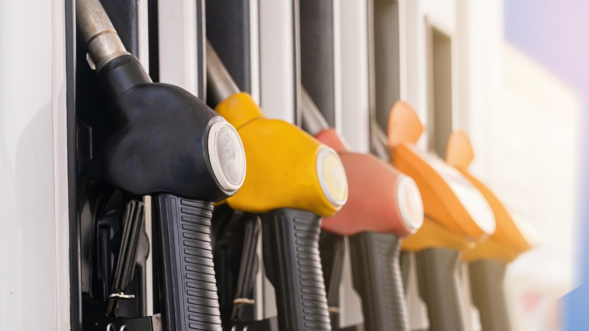 Zapfpistolen in verschiedenen Farben an einer Tankstelle in einer Reihe angeordnet