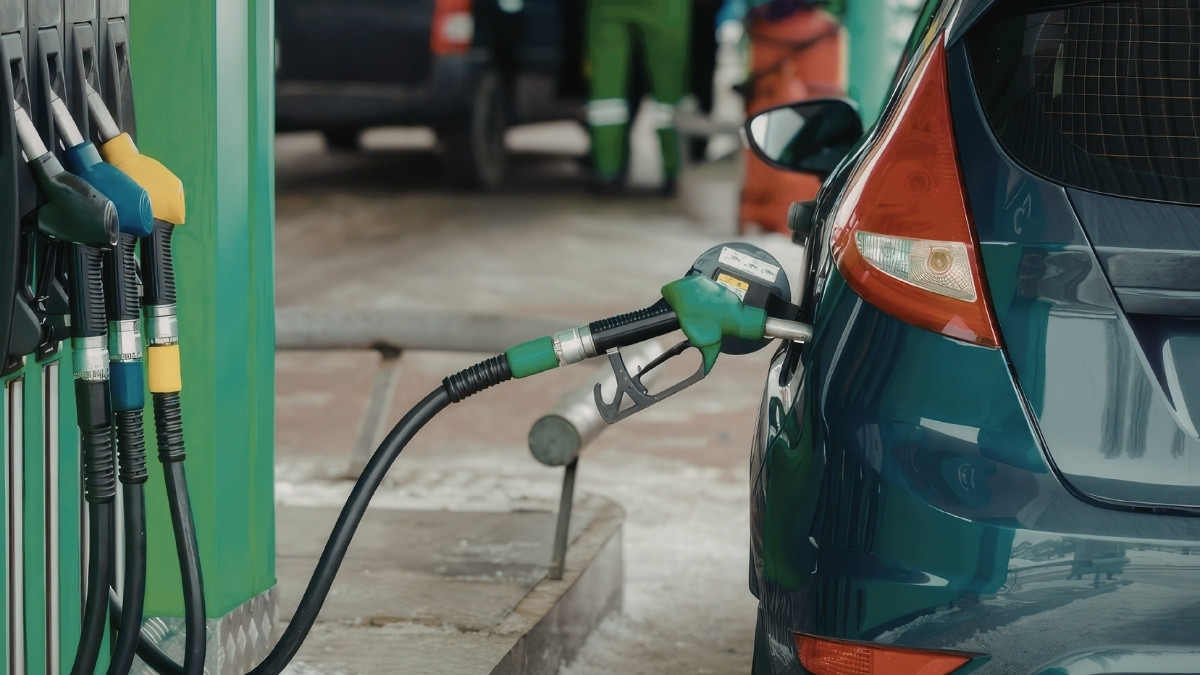 Auto wird an einer Tankstelle betankt, Zapfpistole steckt im Tankstutzen.