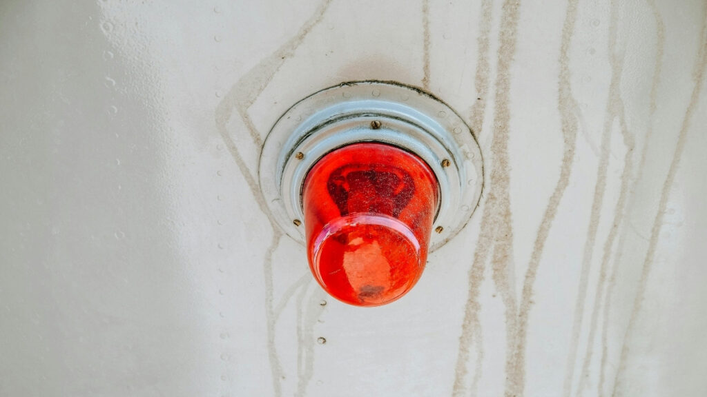 Rotes Warnlicht an einer Wand, das als Signal oder Alarmleuchte dient