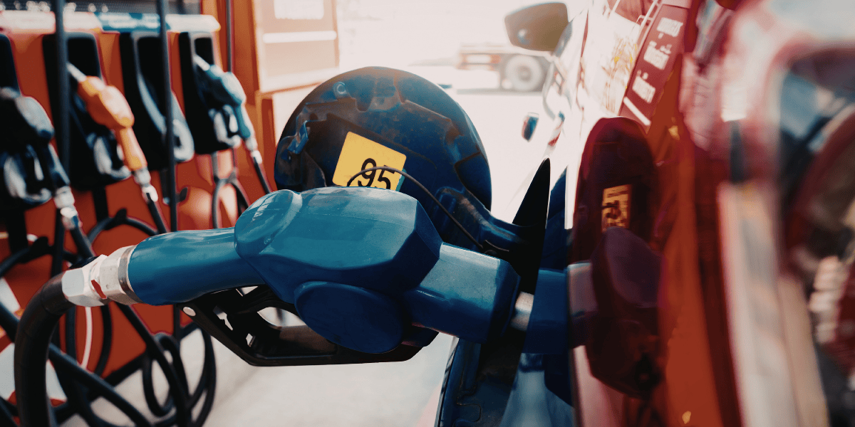 Zapfpistole beim Betanken eines Autos an einer Tankstelle, mehrere Zapfsäulen im Hintergrund