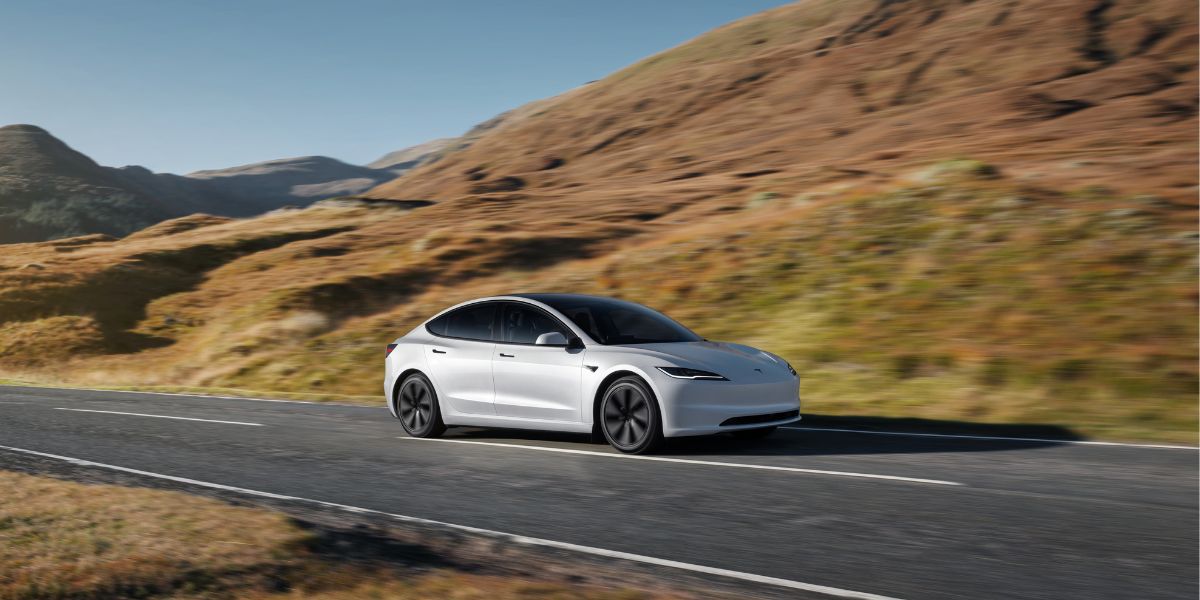 Ein Tesla Auto fährt auf einer Straße in der Natur