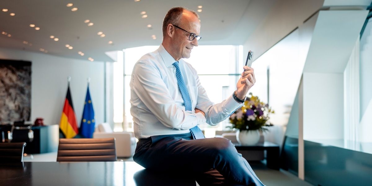 Bundeskanzler Friedrich Merz (mit Handy) bei einem Videotelefonat mit Spielern der deutschen Fußball-Nationalmannschaft im Vorfeld der Weltmeisterschaft (Arbeitszimmer). Das Team bereitet sich in seinem Teamquartier in Winston-Salem (North Carolina) auf das erste Spiel vor.