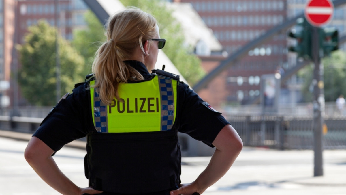 Polizistin steht mit Warnweste auf einer Straße in der Stadt