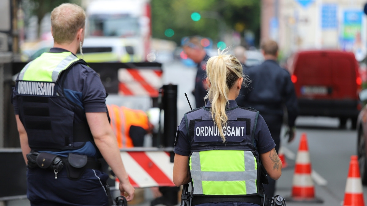 Ordnungsamt-Mitarbeitende mit Warnwesten bei einem Einsatz im Straßenraum mit Absperrungen
