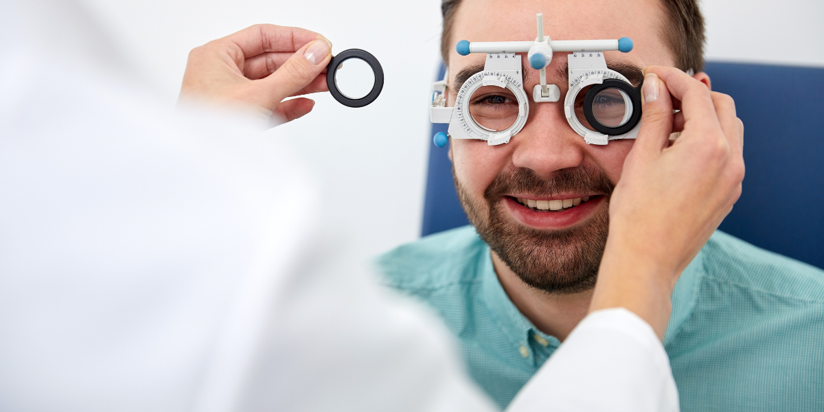 Lächelnder Mann wird mit einer Augenoptiker-Maschine untersucht.
