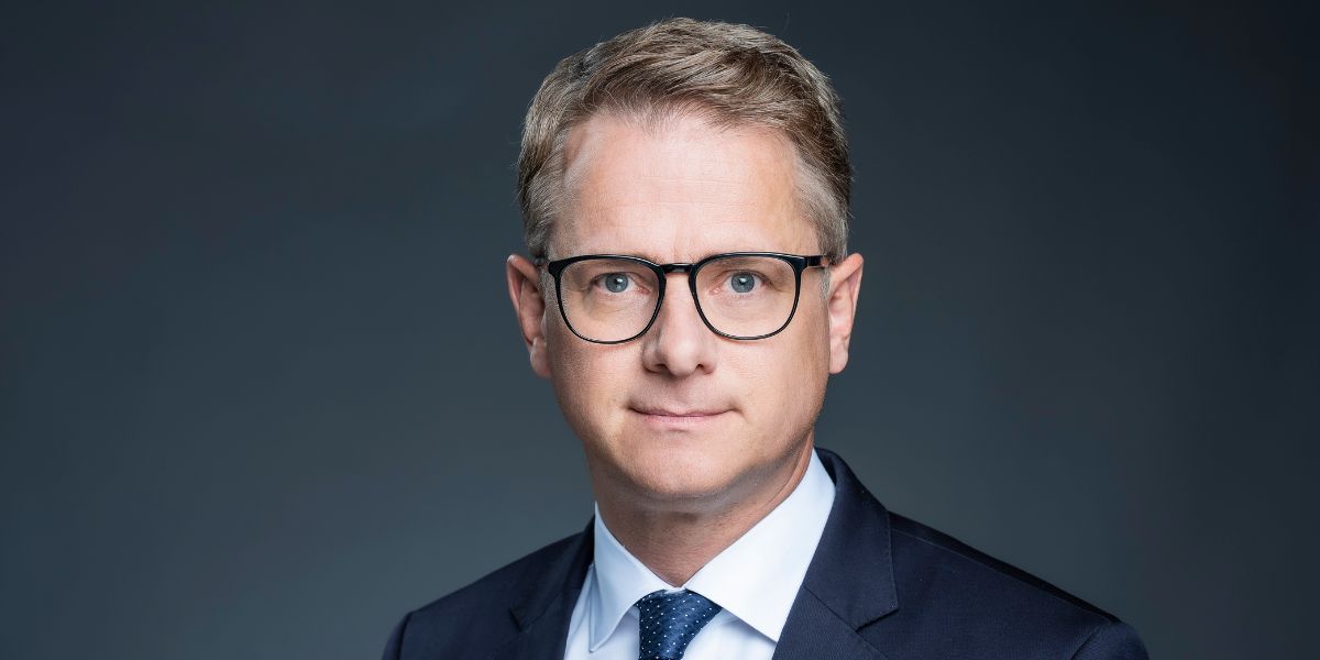 Ein älterer Mann schaut in die Kamera, dunkler Hintergrund